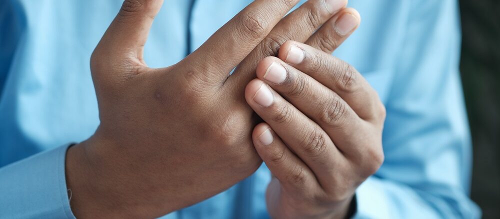 person with joint pain in their fingers