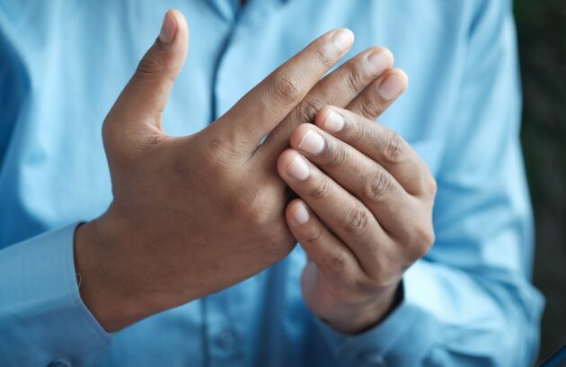 person with joint pain in their fingers
